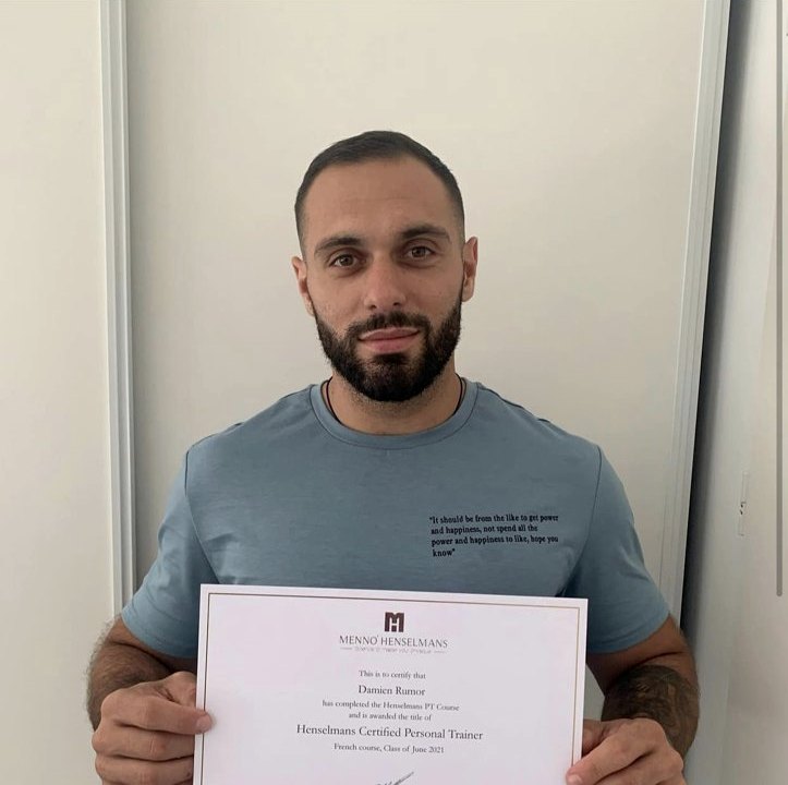 Afgestudeerd personal trainer met zijn certificaat van de online PT-opleiding.